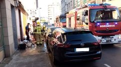 Los bomberos y la Polic�a Local tras sacar a la calle la ropa guardada en el armario que ardi� en el incendio de primera hora de la ma�ana