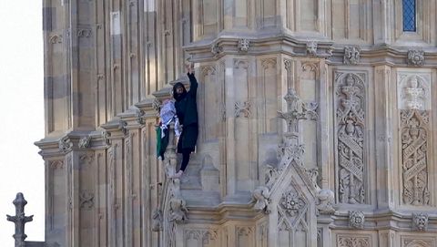 Un hombre trepa la torre del Big Ben con una bandera de Palestina