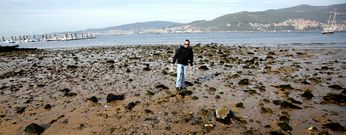 Un agente de la Polic�a Auton�mica arroja al mar las almejas vivas decomisadas ayer en la zona de la playa de Arealonga perteneciente al municipio de Vigo. 
