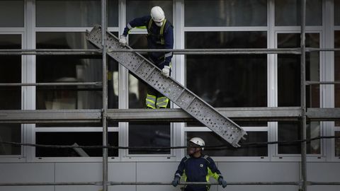 Operarios de Uncisa trabajan en un edificio de la avenida Fisterra