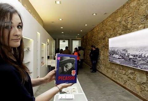 Una joven muestra un libro sobre Picasso en la casa museo del pintor en A Coru�a. 