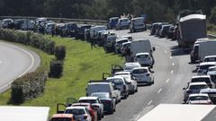 Imagen de una retención en la A-6 en Arteixo, en la que los conductores dejan un paso por el centro para las emergencias.
