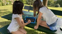 Dos ni�as usando un dispositivo de comunicaci�n alternativa.