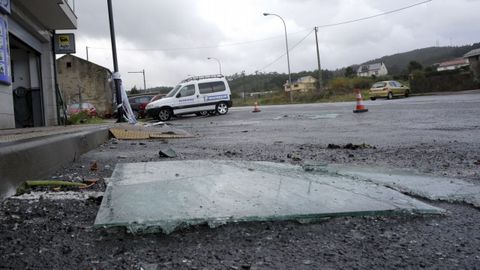 Cristales cados de una terraza de un piso de Arteixo y los destrozos en varios coches