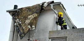 Un bombero en la calle san Roque, sujetando tela asf�ltica.