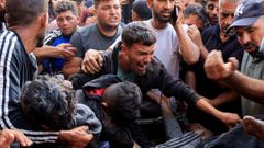 Un grupo de palestinos huye de los ataques israeles, este martes en una cola humanitaria en Jan Yunis.