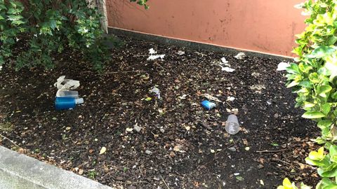 Jardines colindantes al colegio Dolores Medio de Oviedo con numerosos restos de basura