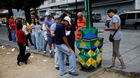 Recarga de móviles en un puesto de energía solar en Caracas
