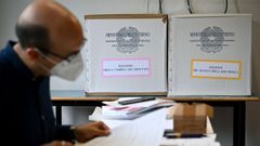 Un agente electoral revisa la documentaci�n para la votaci�n de este domingo en Italia