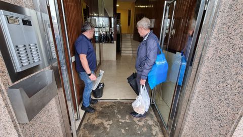 Vecinos de la calle Fernando Olmedo contemplan el efecto de la lluvia en el portal de sus videos