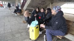 Las j�venes Isabel y Krishna, que perdieron un viaje a Oporto, junto a su familia en la estaci�n de autobuses de Ferrol.