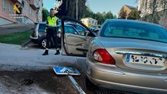 Un agente de la Guardia Civil delante del coche que conduc�a el conductor temerario en Oleiros