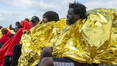 Inmigrantes esperan en el puerto de Teguise (Lanzarote, Canarias) tras arribar a bordo de una patera.