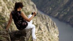 Una mujer saca una foto del ca��n del Sil en las cercan�as del mirador de Santiorxo, en Sober