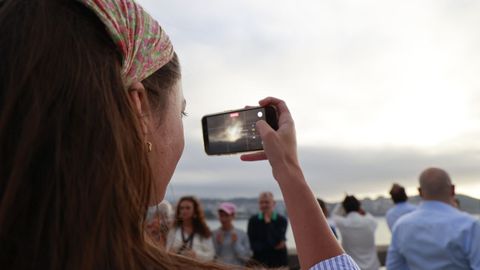 Una joven fotograf�a el cielo nublado durante el eclipse total de sol, en A Coru�a.