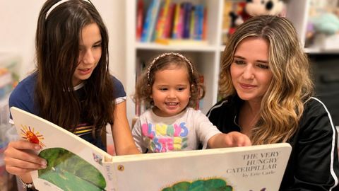 Luj�n junto a sus hijas leyendo un libro en ingl�s