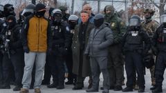 El comandante Gregory Bovino vestido con abrigo verde entre sus hombres, con ropa de tropa militar
