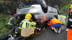 Imagen de los trabajos de excarcelaci�n de la conductora del coche que volc� el mi�rcoles en el mismo punto, a cargo de los Bomberos del Eume