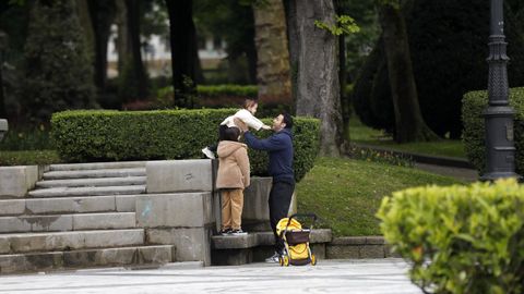 Un hombre juega con sus hijas en un parque del centro de Oviedo,