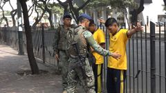 Dos militares cachean a dos estudiantes en una escuela de Guayaquil