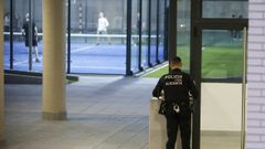 Dos agentes de la Polic�a Local aguardan en la porter�a de las 140 viviendas de protecci�n p�blica (VPP) sometidas a investigaci�n en la Playa de San Juan donde ha iniciado este martes, poco despu�s de las 16.30 horas, un operativo para verificar si los adjudicatarios de residen realmente en el domicilio.