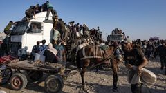 Palestinos desplazados suben a un cami�n de ayuda humanitaria en la Franja de Gaza