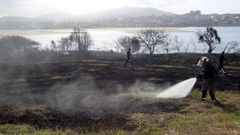 Foto de archivo de un operario de emergencias sofocando un incendio en la costa de Barreiros