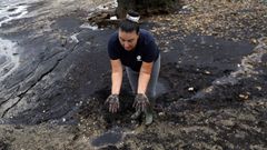 Geno Maneiro muestra el sedimento que cubre la playa.
