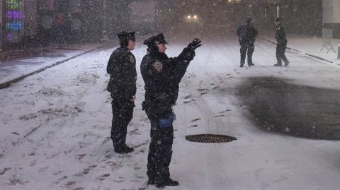 Miembros del cuerpo de polic�a de Nueva York toman fotograf�as durante la tormenta.
