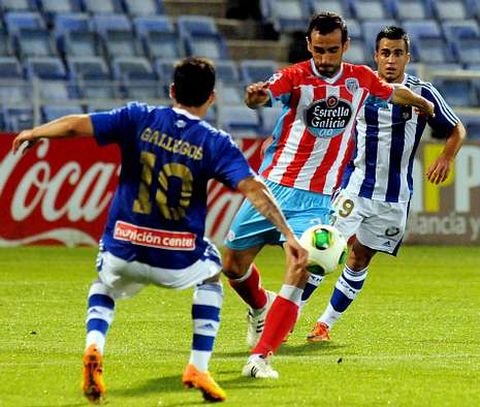 El defensa rojiblanco David de Coz, entre dos jugadores del Recreativo de Huelva. 