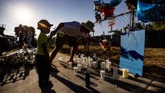 Una hombre y su hijo dejan flores en el lugar en que fue tiroteado Dijon Kizzee en Los �ngeles