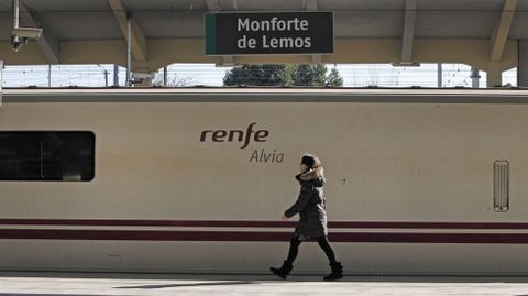 Una pasajera pasa frente a un tren Alvia detenido en la estacin de Monforte