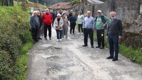 Vecinos de Sillobre en la carretera llena de baches que lleva a sus casas. 