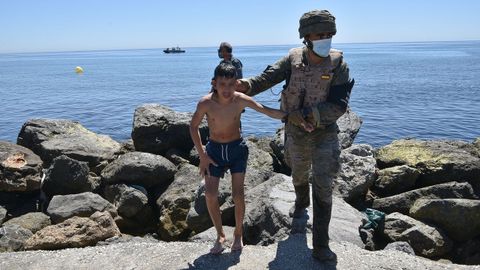 Un militar del ejrcito espaol ayuda a un menor migrante procedente de Marruecos a su llegada a Ceuta