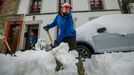 Vecinos de la localidad asturiana de Pajares, que está en nivel rojo con lo que se prohíbe la circulación de vehículos articulados, camiones y autobuses, retiran la nieve de los caminos.