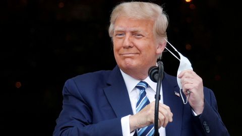 Donald Trump se saca la mascarilla antes de su intervención, este sábado, en el jardín de la Casa Blanca