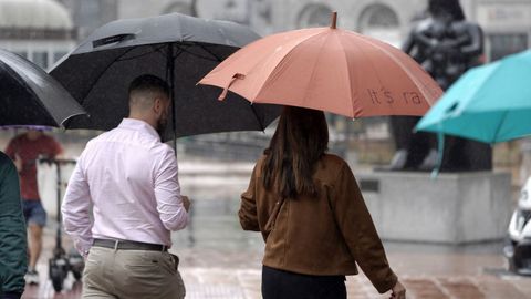 Viandantes con paraguas protegi�ndose de la lluvia en el centro de Oviedo