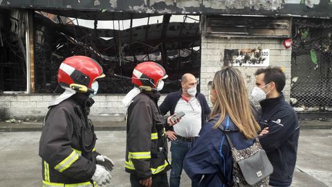 Silvota.La consejera de Presidencia, Rita Camblor, y el director general de de Seguridad y Estrategia Digital, Javier Fern�ndez, junto a las naves de Llanera calcinadas por el incendio 