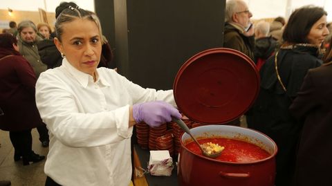 Una de las camareras que sirvieron las raciones de caldo muestra el contenido de una de las ollas en las que se cocin�