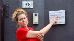 Rebeca Rebolo, en el acceso del hogar O Lecer, se�alando el r�tulo que advierte de la supresi�n de las visitas al centro