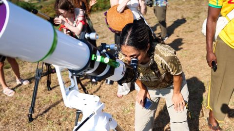 Una mujer mirando el eclipse por un telescopio en Doni�os. 