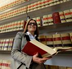 Cristina Bugar�n delante de los anaqueles donde se hallan la enciclopedia de Aranzadi.