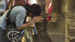 Imaxe de arquivo dunha turista no Santo dos Croques da Catedral compostel� cando a�nda se pod�a tocar a escultura