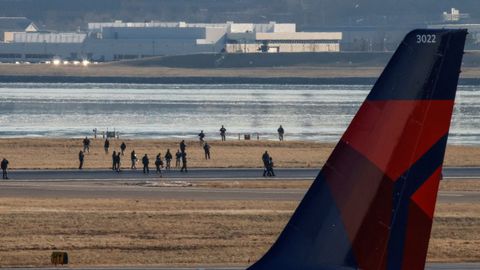 Miembros del personal de Emergencias caminan por el aeropuerto Ronald Reagan en Washington