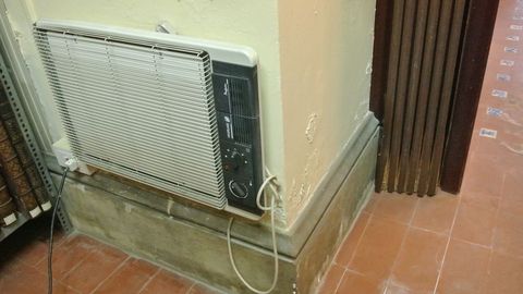 Un viejo radiador eltrico colgado de una pared daada 