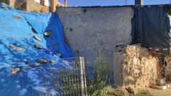 Los escombros de la casa que se desplom� est�n tapados por una lona.