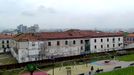 El edificio de Tabacalera, visto desde el cerro de Santa Catalina, con Gijón al fondo