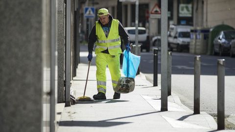 Un limpiador barriendo la calle en Ribadavia en el primer da laborable con el estado de alarma.