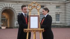 Los lacayos Stephen Kelly y Sarah Thompson sacan el caballete de la explanada del Palacio de Buckingham para anunciar formalmente el nacimiento del hijo del pr�ncipe Harry y su mujer Meghan Markle, duquesa de Sussex en Londres