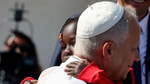 El papa abraza a una ni�a.